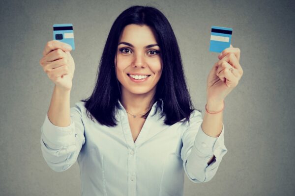 woman holding up two pieces of a credit card