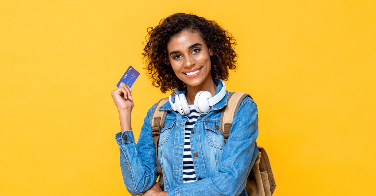 Women holding a credit card with a yellow background