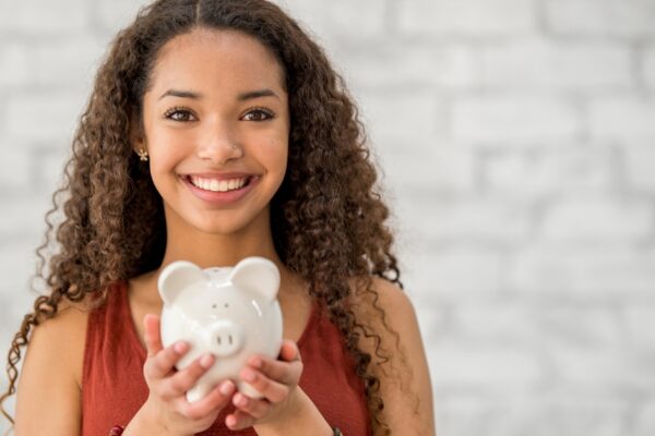 teenager holding a piggy bank